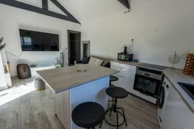 a kitchen with a counter and a kitchen island with stools at Maison Tiki Village Aix centre in Aix-en-Provence