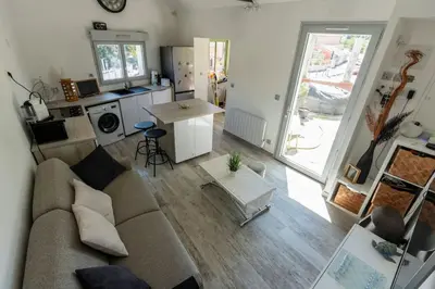 a living room with a couch and a table and a kitchen at Maison Tiki Village Aix centre in Aix-en-Provence