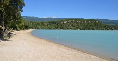 a beach with people swimming in the water at Charmante maison de village au coeur du Luberon in Cucuron