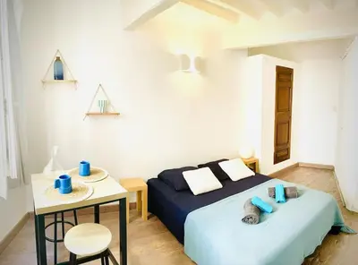 a bedroom with a blue bed and a table with a chair at Studio le Méditerranée in Aix-en-Provence