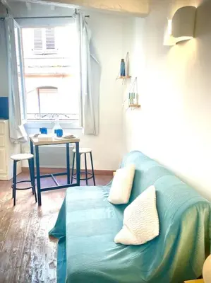 a living room with a couch and a table at Studio le Méditerranée in Aix-en-Provence