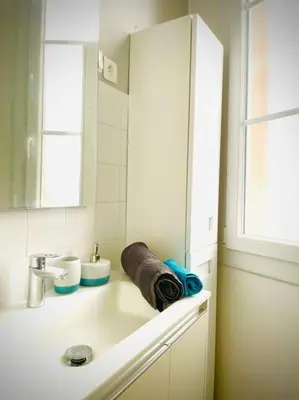 a white bathroom with a sink and a mirror at Studio le Méditerranée in Aix-en-Provence