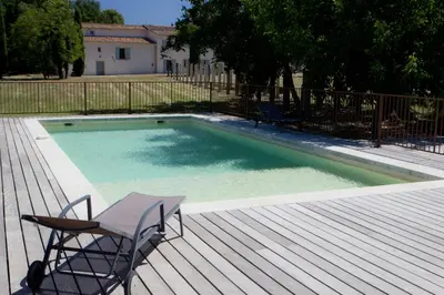 a deck with a chair and a swimming pool at Château La Croix Des Pins in Mazan