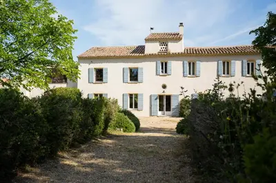 an exterior view of a large white house with trees at Château La Croix Des Pins in Mazan
