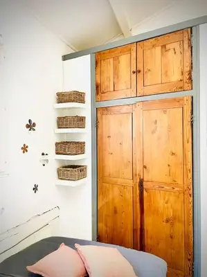 a bedroom with a wooden door and baskets on the wall at Appartement Le Provençal in Aix-en-Provence