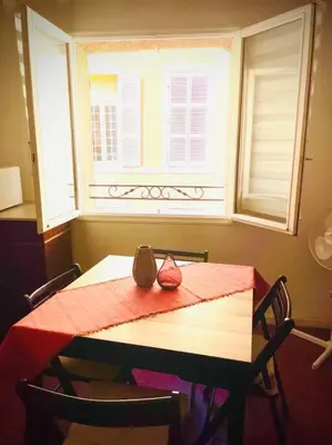 a table with a red table cloth and a window at Appartement Le Provençal in Aix-en-Provence