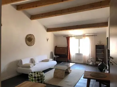 a living room with a white couch and a table at Appartement avec terrasse. in Apt