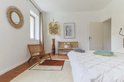 a bedroom with a bed and a chair and a mirror at Mas Le Cerf in Eyragues