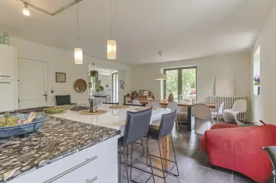 a kitchen and living room with a table and chairs at Mas Le Cerf in Eyragues