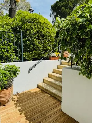 a set of stairs next to a white wall with plants at LES CISTES in Mallemort