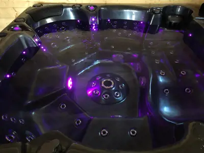 a black bath tub with purple lights on it at Une Pause Douceur - Suite All in Wood in Eyguières