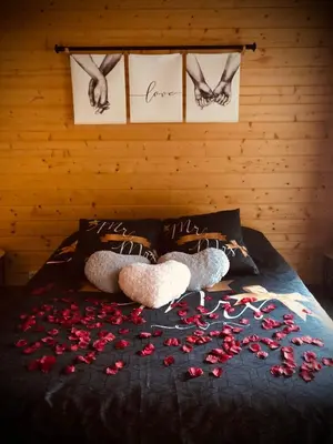 two stuffed animals laying on a bed with roses on it at Une Pause Douceur - Suite All in Wood in Eyguières