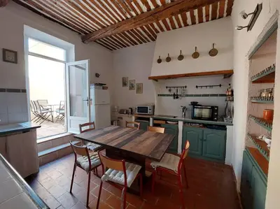 a large kitchen with a wooden table and chairs at Maison de César in Saint-Saturnin-les-Apt