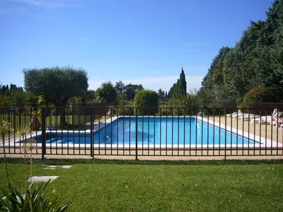 a fence around a swimming pool in a yard at Les Tournesols in Saint-Andiol
