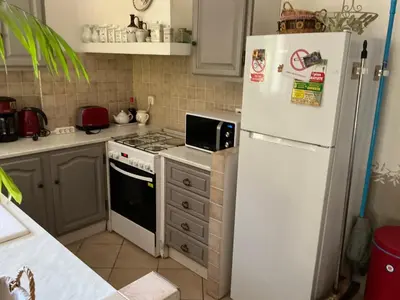 a kitchen with a white refrigerator and a stove at Les Tournesols in Saint-Andiol