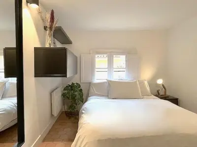 a bedroom with a white bed and a window at LUXURY Enchanting Duplex Aix Center in Aix-en-Provence