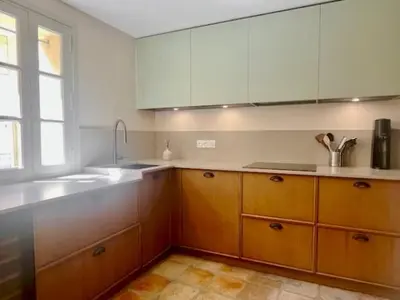 a kitchen with wooden cabinets and a sink and a window at LUXURY Enchanting Duplex Aix Center in Aix-en-Provence