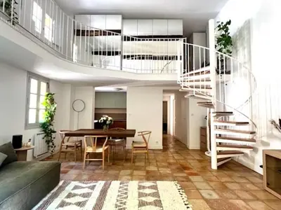 a living room with a table and a spiral staircase at LUXURY Enchanting Duplex Aix Center in Aix-en-Provence