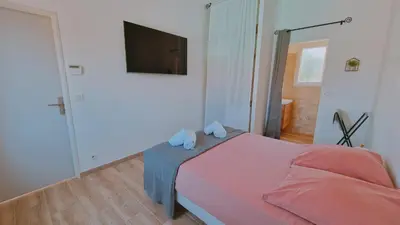 a bedroom with a bed and a flat screen tv at La perle du sud in Carpentras