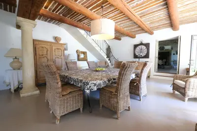 a dining room with a table and wicker chairs at magnificient property with heated swimming-pool in the luberon - 14 persons in Les Taillades