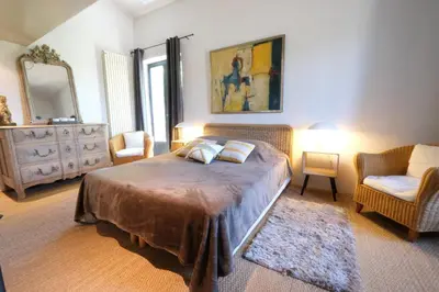 a bedroom with a bed and two chairs and a mirror at magnificient property with heated swimming-pool in the luberon - 14 persons in Les Taillades