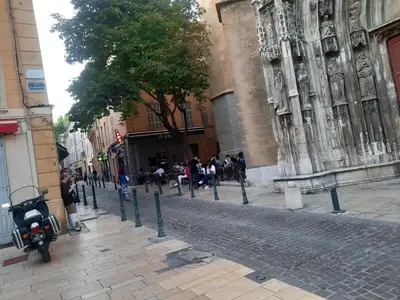 a group of people walking down a cobblestone street at Studio cathédrale centre Aix-en-Provence in Aix-en-Provence
