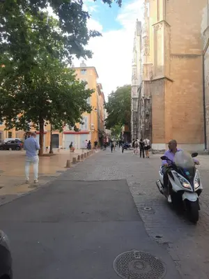 a person riding a motorcycle on a city street at Studio cathédrale centre Aix-en-Provence in Aix-en-Provence