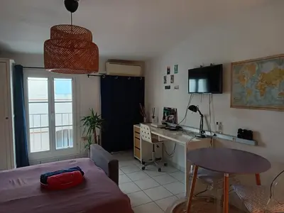 a living room with a table and a desk in a room at Studio cathédrale centre Aix-en-Provence in Aix-en-Provence