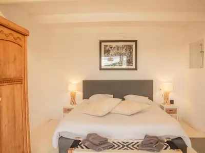 a bedroom with a bed with white sheets and pillows at La Roque in La Roque-sur-Pernes
