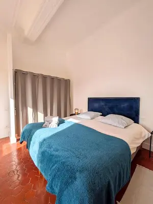 two beds in a bedroom with a blue blanket at UNE TERRASSE SUR LES TOITS in Aix-en-Provence
