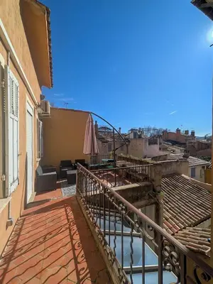 a balcony of a building with an umbrella at UNE TERRASSE SUR LES TOITS in Aix-en-Provence