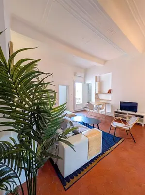 a living room with a couch and a palm tree at UNE TERRASSE SUR LES TOITS in Aix-en-Provence