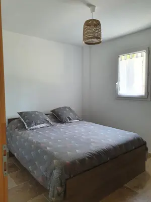 a bedroom with a bed in a room with a window at Petite maison en campagne in Pernes-les-Fontaines