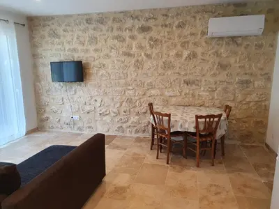 a dining room with a table and chairs against a stone wall at Petite maison en campagne in Pernes-les-Fontaines