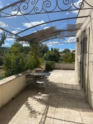 a bedroom with a bed with a large headboard at Appartement dans bastide à Saint Rémy de Provence in Saint-Rémy-de-Provence