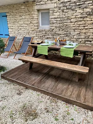 a wooden table and chairs on a wooden deck at Cigale de Gordes in Gordes