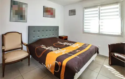a bedroom with a bed and a chair and a window at Gorgeous Home In Aubignan in Aubignan