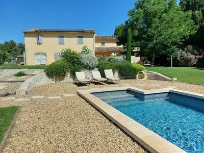 a swimming pool in a yard with two chairs and a house at En Provence, Chez Stéphanie et Marcel in Saint-Rémy-de-Provence