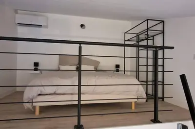 a bedroom with a bed with a black metal frame at Cosy House in Carpentras
