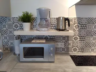 a microwave oven sitting on a counter in a kitchen at Les Studios proche du Mont Ventoux in Mazan