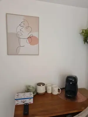 a table with cups and a picture on the wall at La pause en luberon in Cavaillon