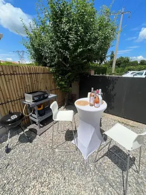 a backyard with a grill and a table and chairs at La pause en luberon in Cavaillon