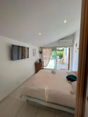 a bedroom with a large bed and a tv on the wall at La pause en luberon in Cavaillon