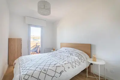 a white bedroom with a bed and a table at Charmant T3 proche centre ville avec parking in Aix-en-Provence