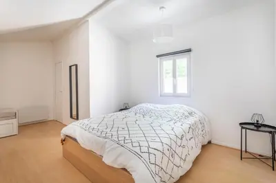 a white bedroom with a bed and a window at Charmant T3 proche centre ville avec parking in Aix-en-Provence