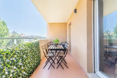 a patio with two chairs and a table on a balcony at Charmant T3 proche centre ville avec parking in Aix-en-Provence