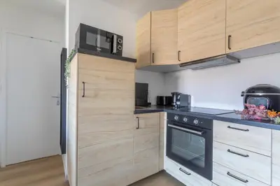 a kitchen with wooden cabinets and a stove top oven at Charmant T3 proche centre ville avec parking in Aix-en-Provence
