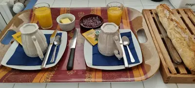 a table with two plates of food and two glasses of orange juice at Chambre d'hôte BB proche d'Aix en Provence in Éguilles