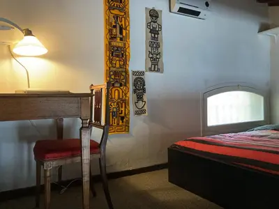 a bedroom with a desk and a bed and a lamp at Le Cardinale - Un Voyage en Provence - 2 chambres avec parking in Aix-en-Provence