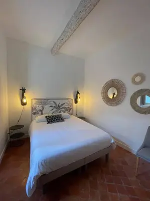 a bedroom with a bed and a mirror on the wall at Maison de village in Pernes-les-Fontaines